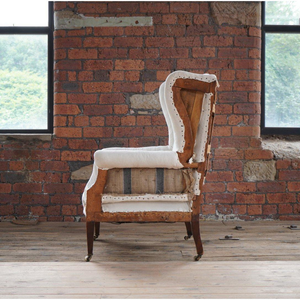 English wingback armchair with tapered legs and brass castors-Antique Seating-KONTRAST
