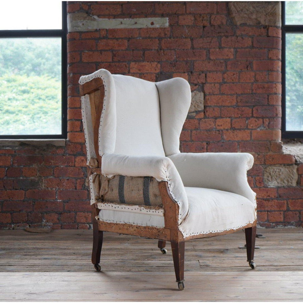 English wingback armchair with tapered legs and brass castors-Antique Seating-KONTRAST
